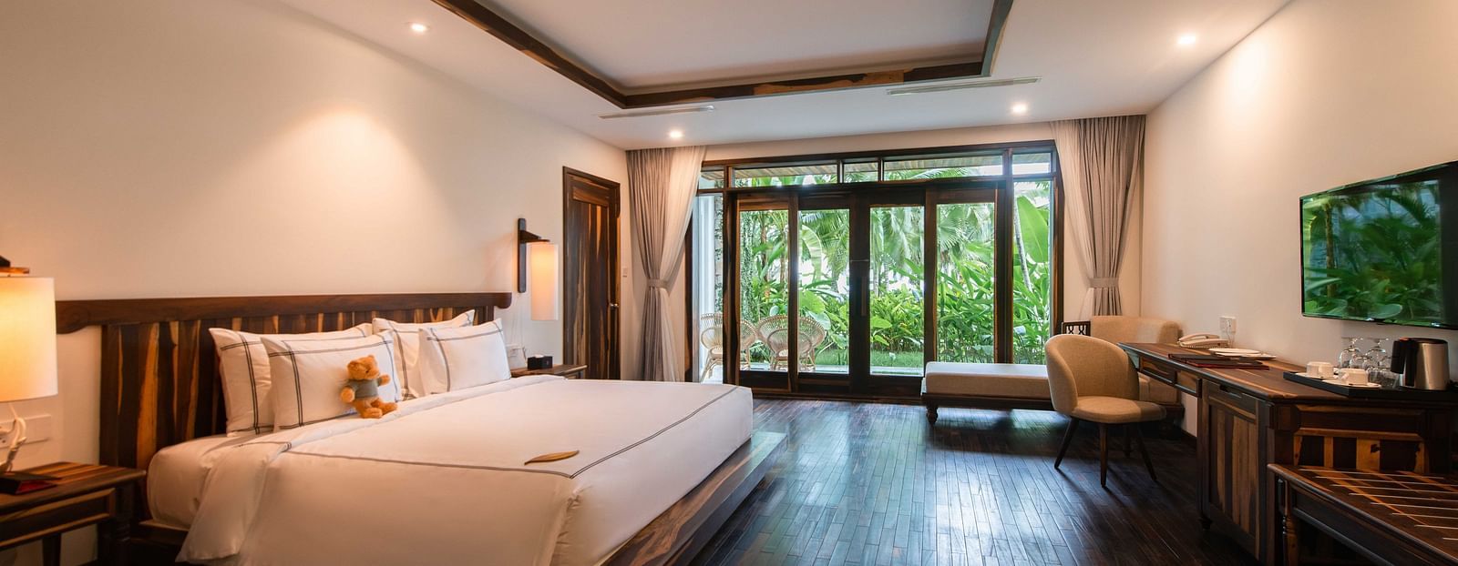 King size bed, a work desk, comfortable chair in our rooms with a garden view - Alibu Resort Nha Trang
