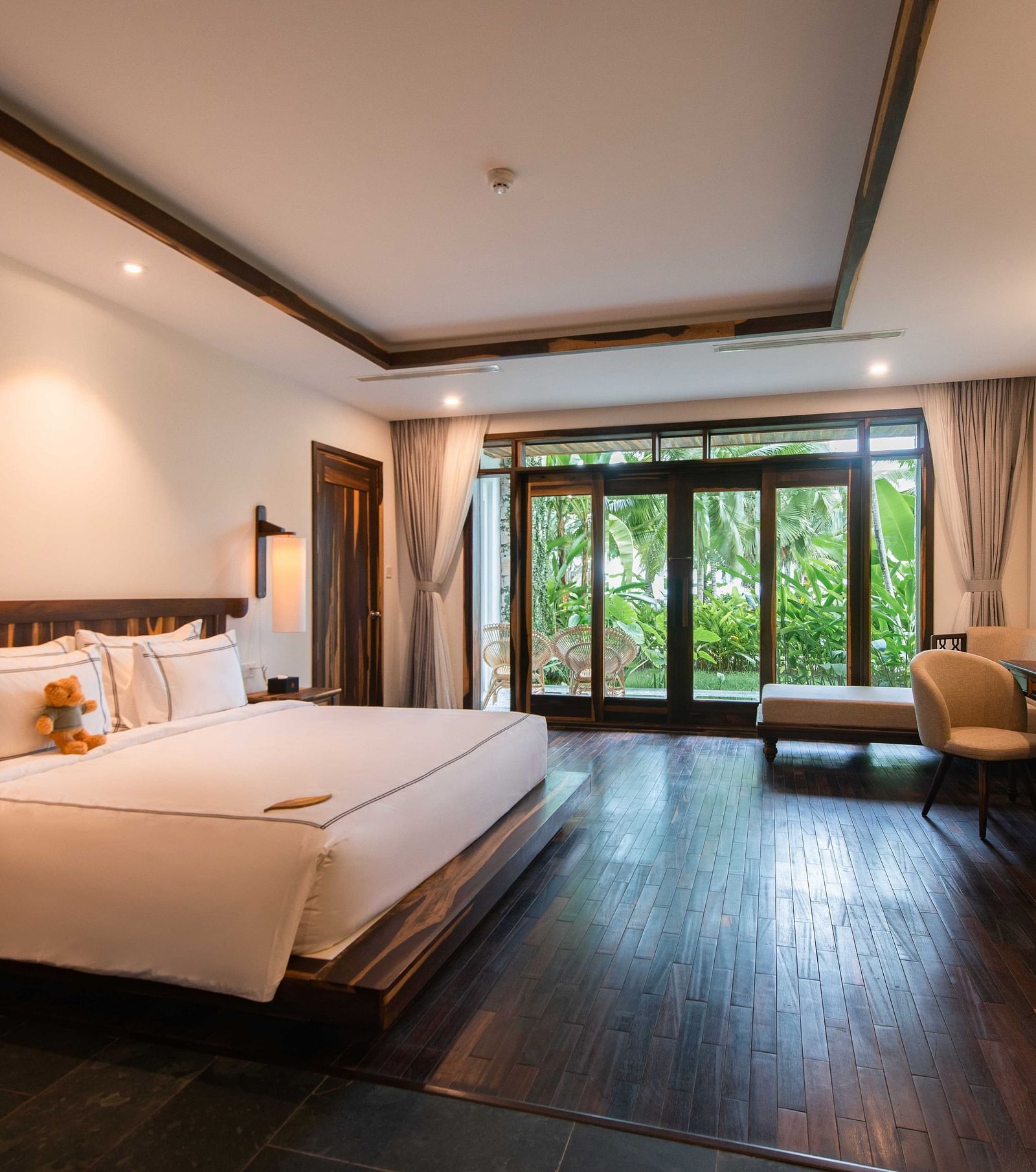 King size bed, a work desk, comfortable chair in our rooms with a garden view - Alibu Resort Nha Trang