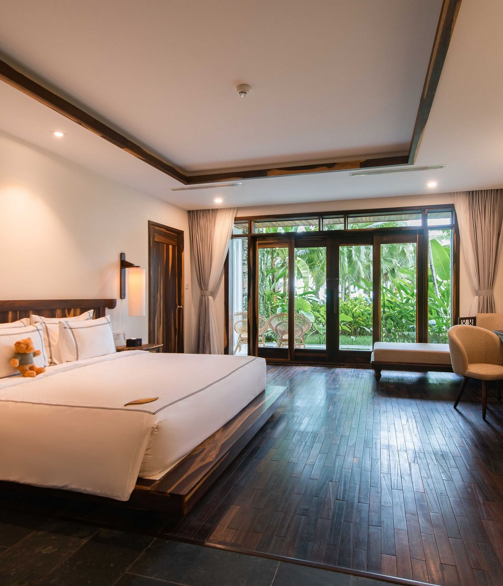 King size bed, a work desk, comfortable chair in our rooms with a garden view - Alibu Resort Nha Trang