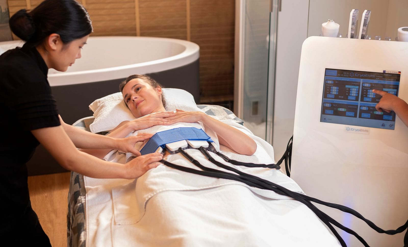 A woman administering the CYRO EMS TREATMENT on a client at The Claridges New Delhi