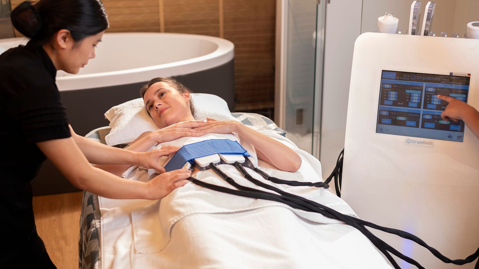 A woman administering the CYRO EMS TREATMENT on a client at The Claridges New Delhi