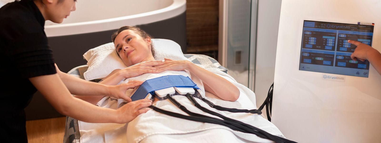 A woman administering the CYRO EMS TREATMENT on a client at The Claridges New Delhi