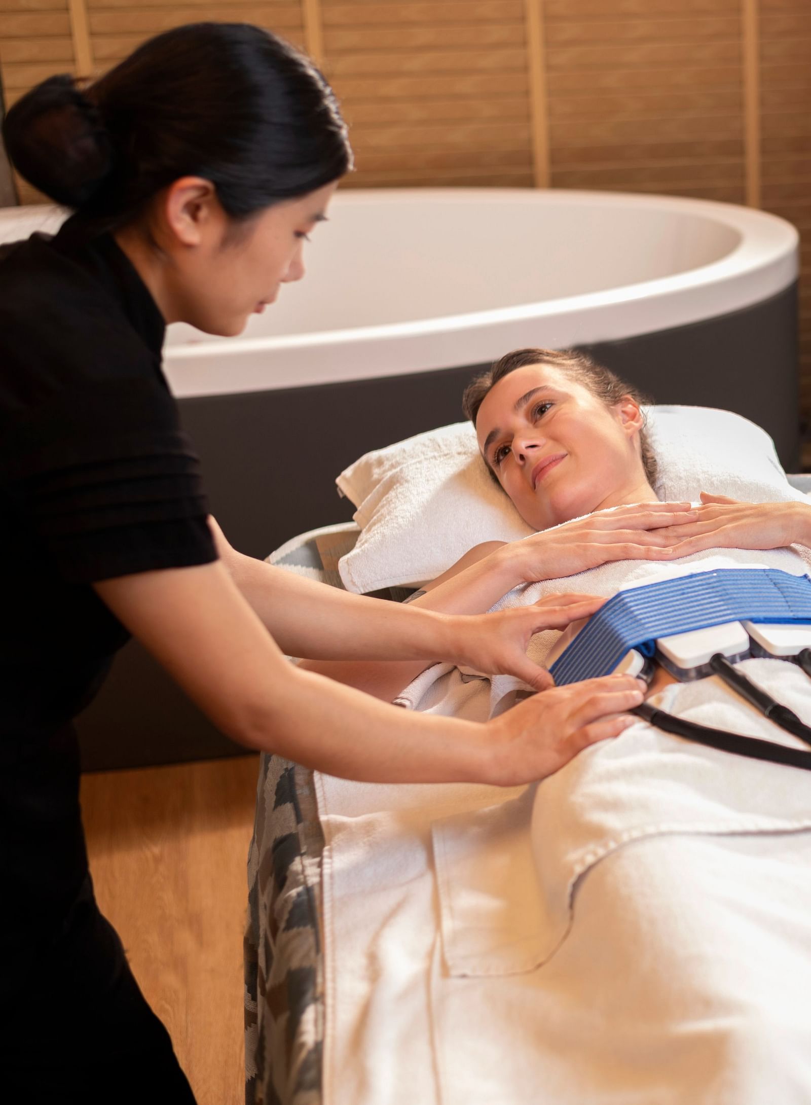 A woman administering the CYRO EMS TREATMENT on a client at The Claridges New Delhi