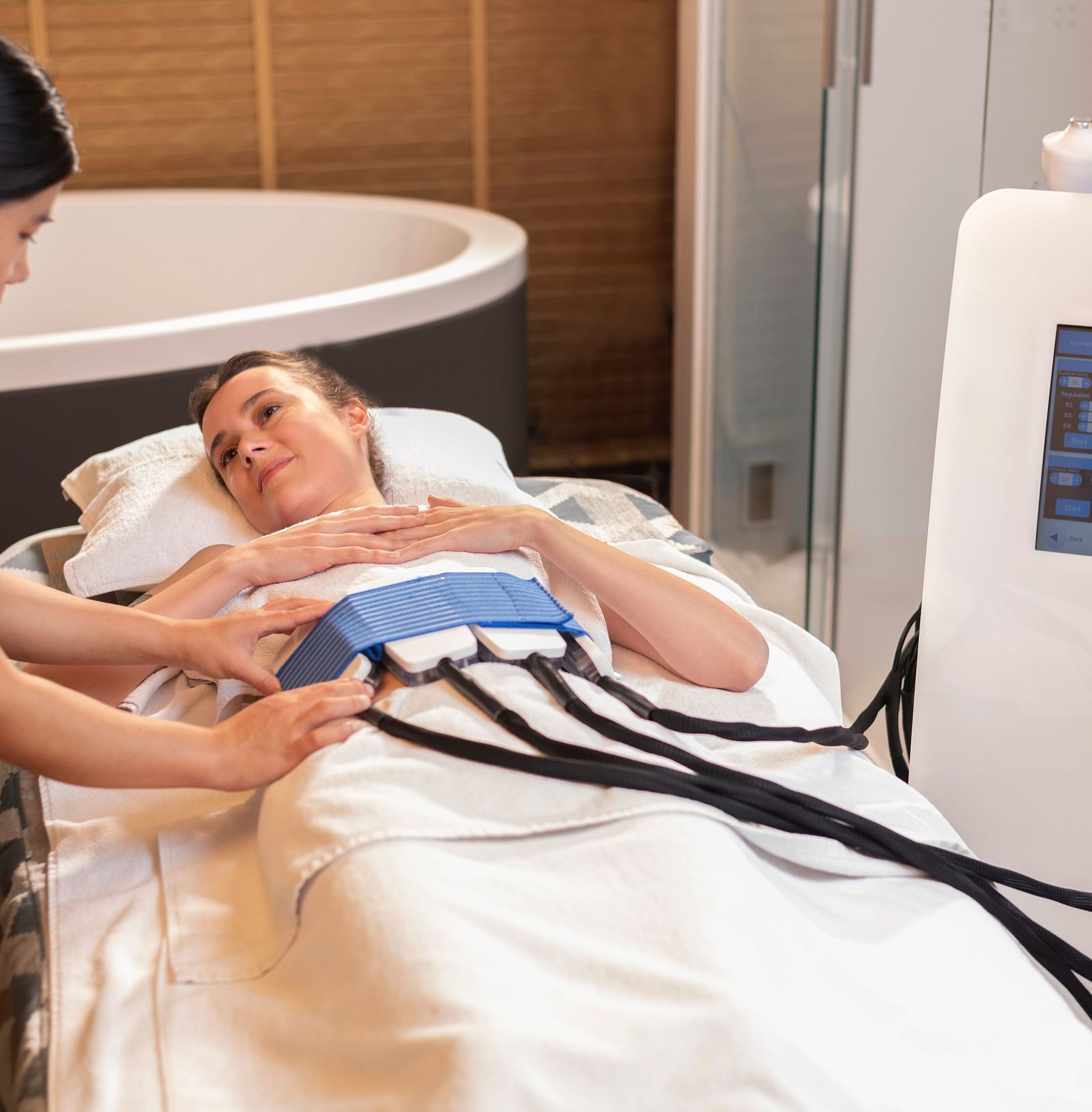 A woman administering the CYRO EMS TREATMENT on a client at The Claridges New Delhi