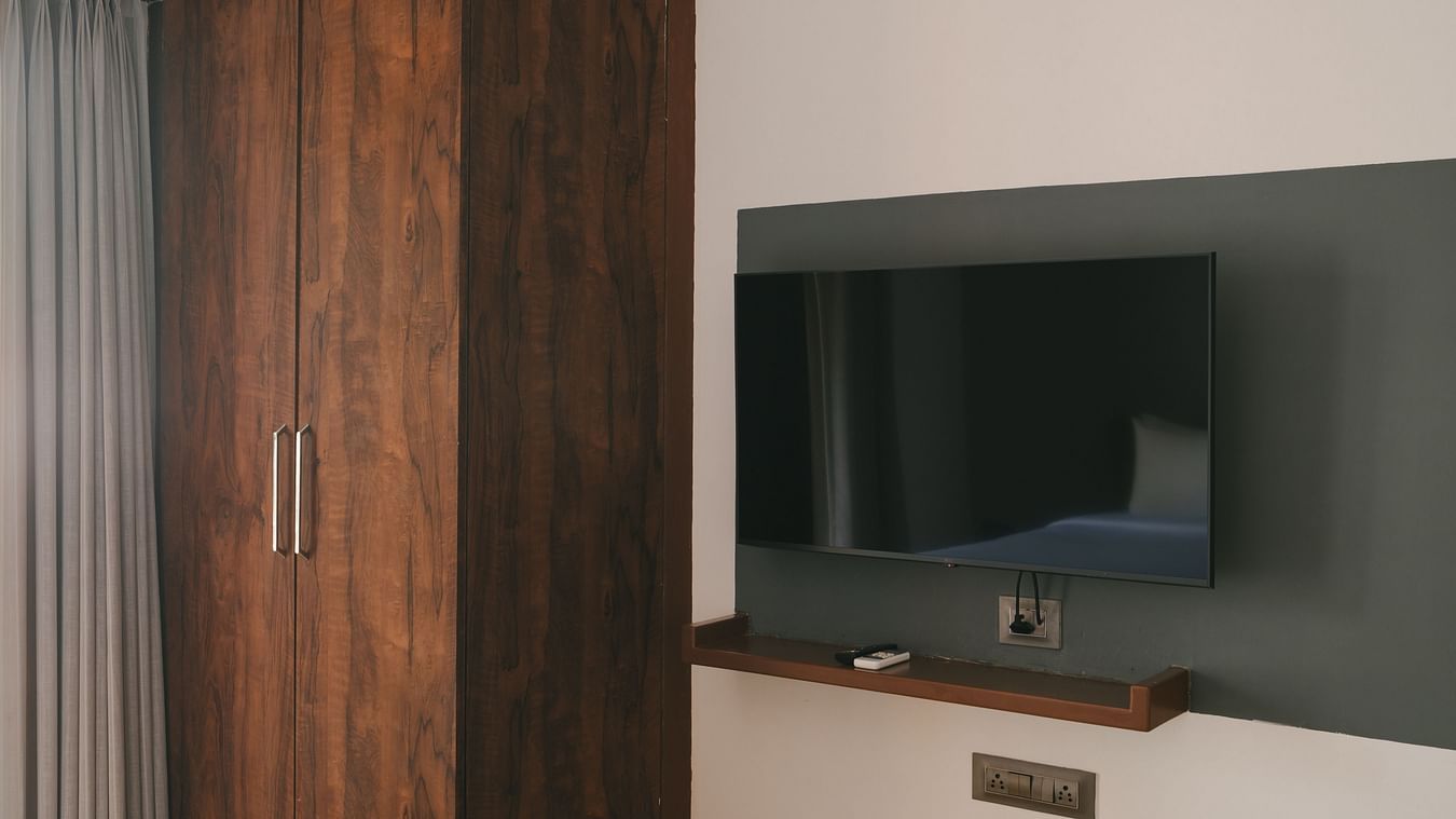 Bedroom with a sleek wardrobe and TV setup at the Two BHK apartment in Richmonde Ananta Elite, Goa.