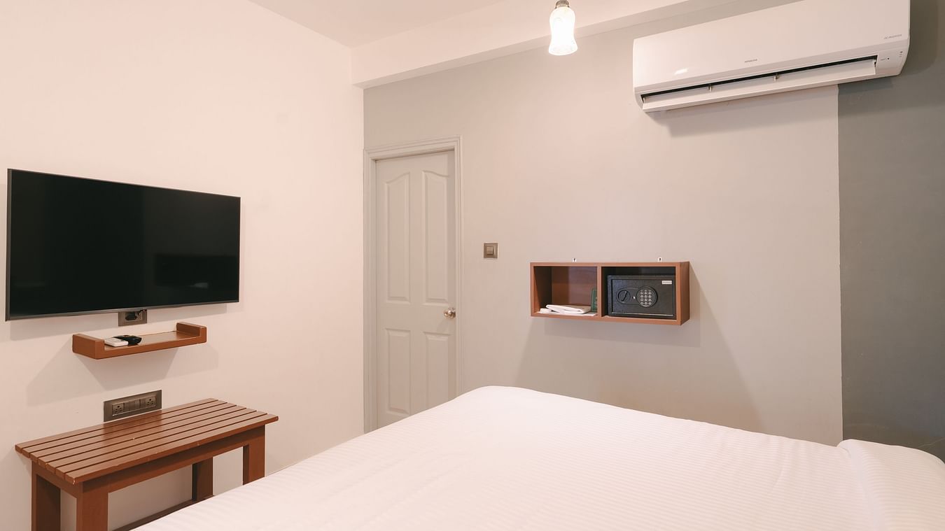 Modern bedroom with a wall-mounted TV and air conditioning at the Two BHK apartment in Richmonde Ananta Elite, Goa.