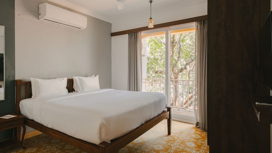 Spacious bedroom with a comfortable bed and balcony view at the Two BHK apartment in Richmonde Ananta Elite, Goa.