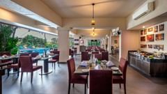 Outdoor dining area at Golden Tulip, offering a cosy atmosphere with wooden furniture and greenery.