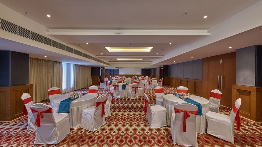 well-decorated tables and chairs set up in cluster arrangement in our banquet hall in mahabalipuram - Grand Continent, Mahabalipuram