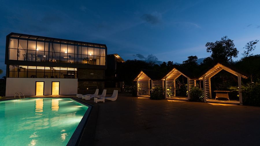 image of the poolside space featuring the separate outdoor seating area on a late evening - Darza Resorts