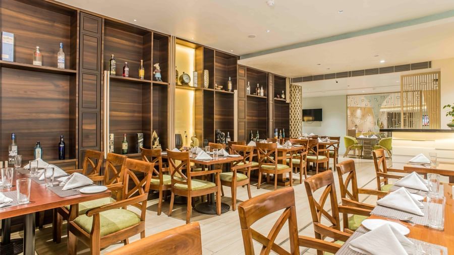 Hotel restaurant featuring wooden accents, set tables, and soft lighting | The Citi Residenci Hotel Durgapur