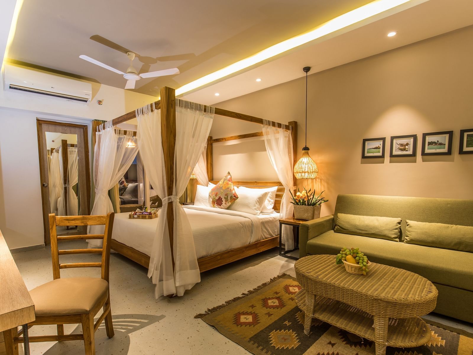 A room at Swosti Chilika Resort with a double bed, sofa seating and work desk and chair