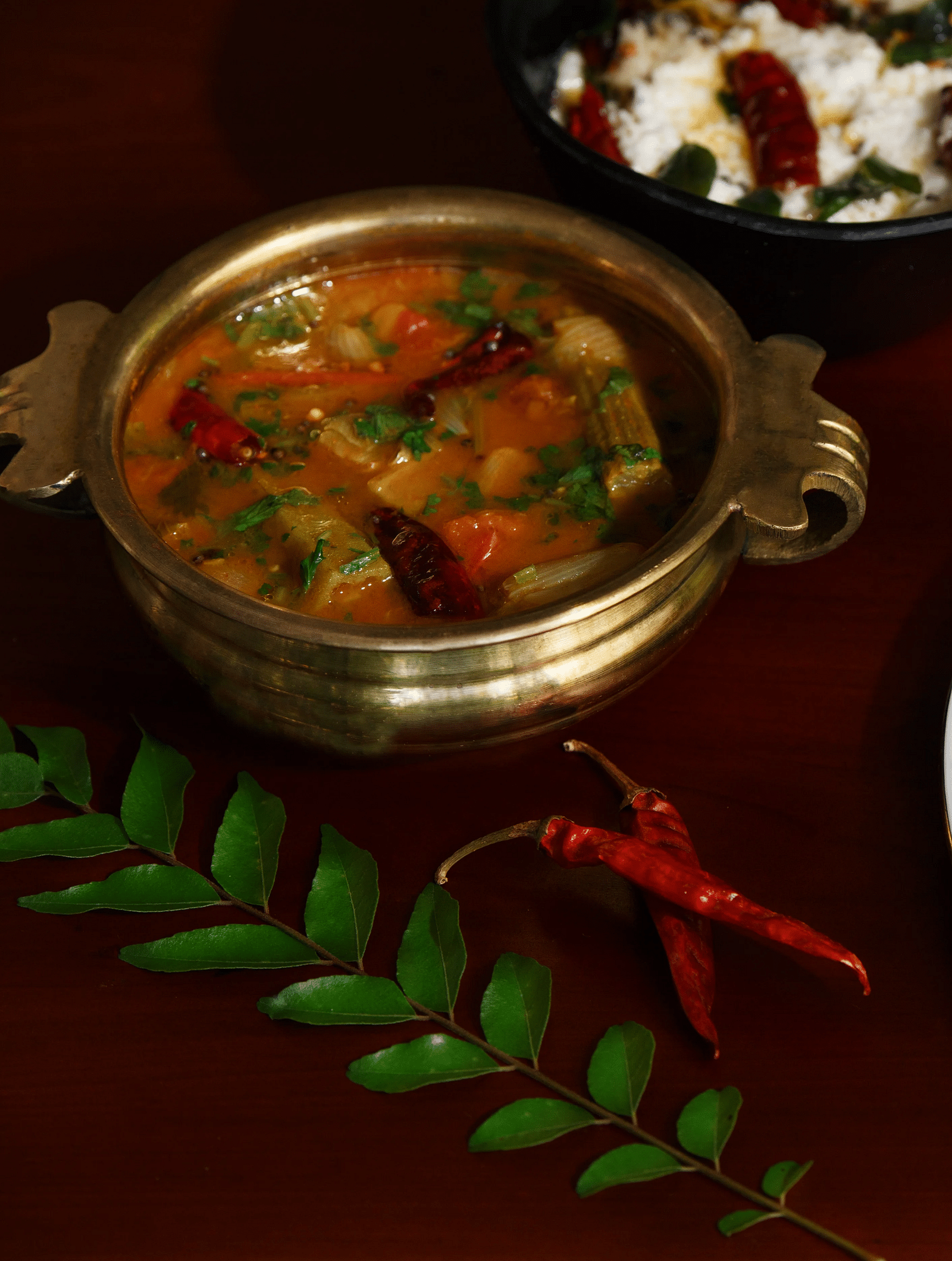 A top-down view of a plate with South Indian cuisine, what appears to be dosa, sambar, and chutneys.