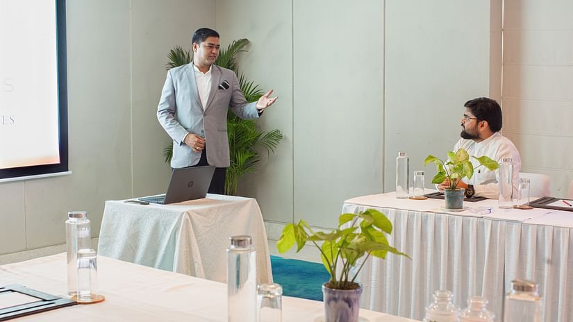 a person speaking to another person inside an event hall - Karma Lakelands.