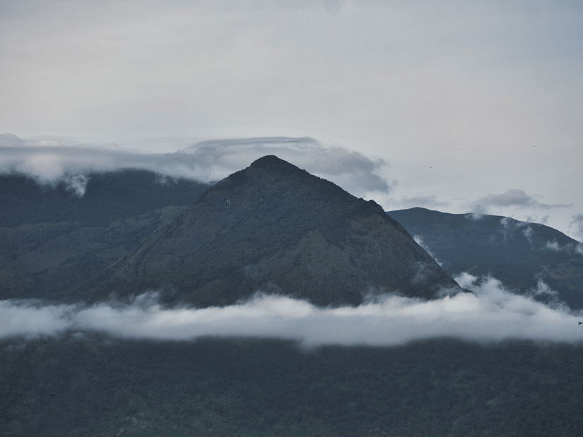 A wide shot of a hill covered with white clouds.