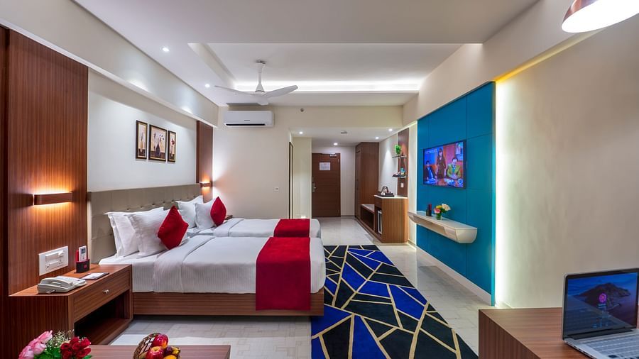 Hotel room featuring a double bed, desk, and relaxing lighting for a comfortable stay - Lords Eco Inn Shapar Rajkot