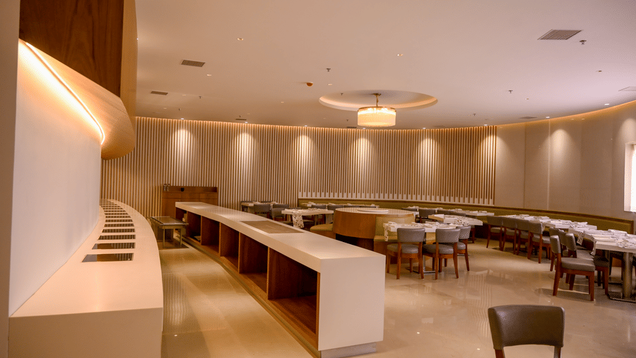 A spacious dining room interior displaying a long built in buffet service station and clustered tables with chairs at Tiara by MPS.