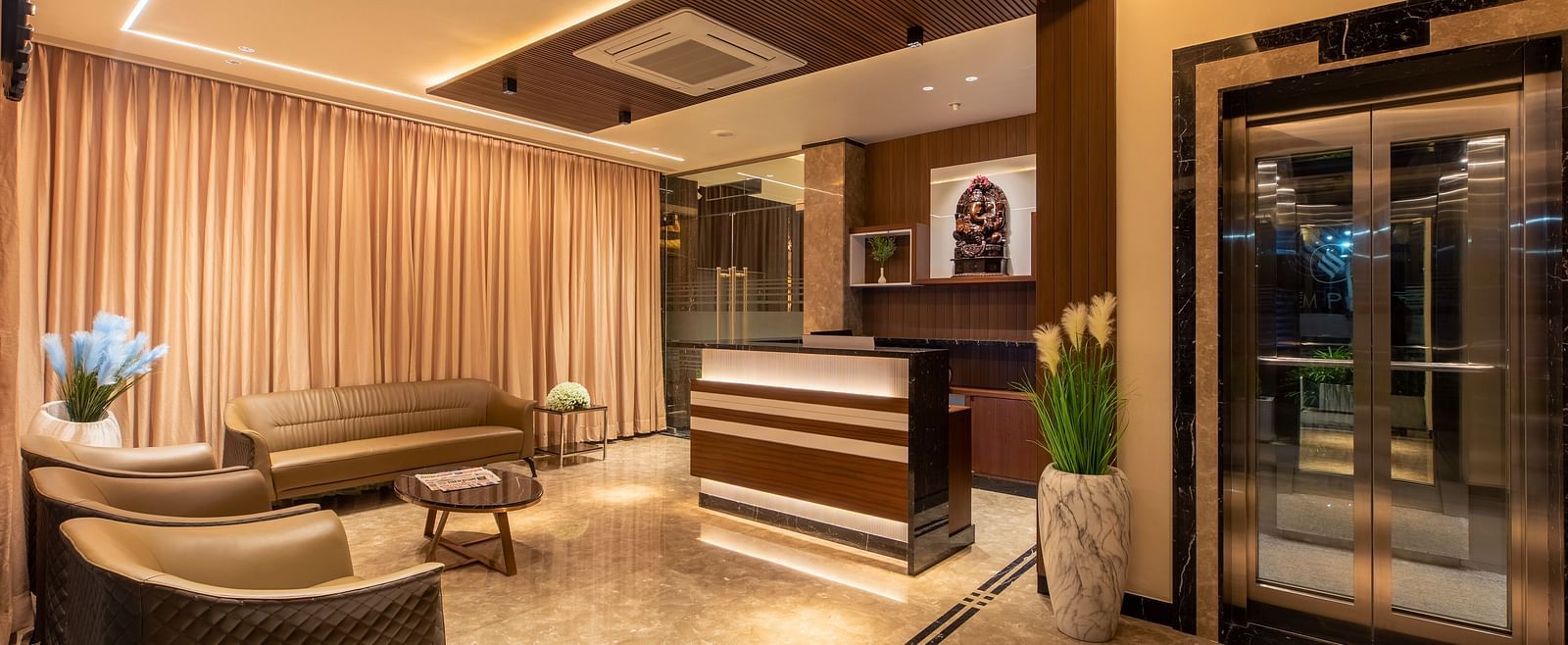An image showcasing the reception area, featuring sofas and a table at M Pro Palace.