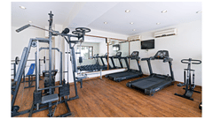 A clean and well-equipped hotel gym with various exercise machines, including treadmills and a weight machine - Clarks Avadh, Lucknow