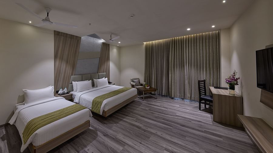 A king bed and a single bed inside family room at Grand Continent - A Sarovar Premiere Affiliate Hotel, Hosur