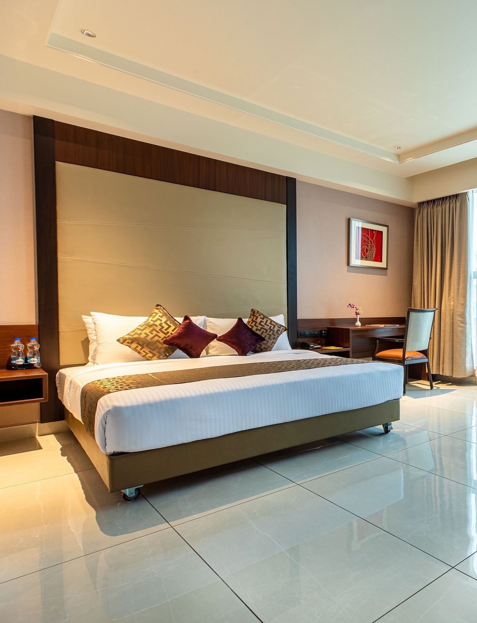 An image of a room with a bed, complemented by large windows on the side at M Pro Palace.
