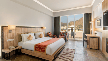 A spacious kumbhalgarh resort room at Via Lakhela Resort & Spa in Kumbhalgarh, featuring a king size bed, modern amenities, and serene views of the surrounding hills.