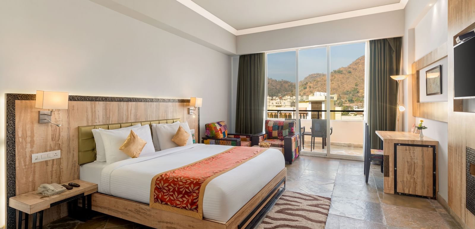 A spacious Deluxe Non-Lake View Room at Via Lakhela Resort & Spa in Kumbhalgarh, featuring a king-size bed, modern amenities, and serene views of the surrounding hills