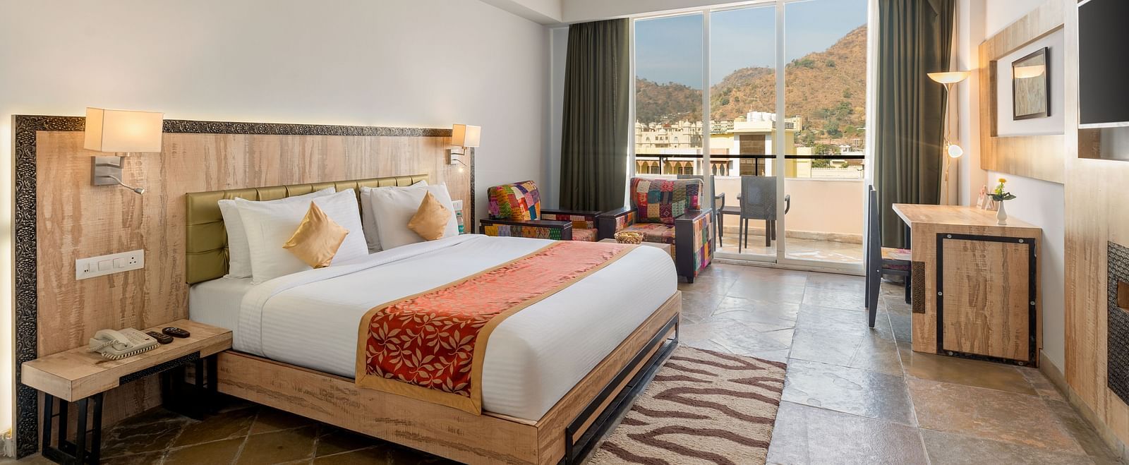 A spacious Deluxe Non-Lake View Room at Via Lakhela Resort & Spa in Kumbhalgarh, featuring a king-size bed, modern amenities, and serene views of the surrounding hills