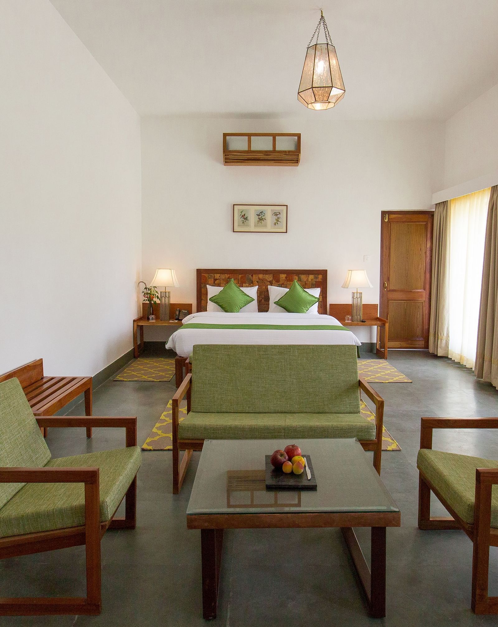A room at Saraca Resort & Spa Corbett with a double bed and a seating arrangement around a coffee table