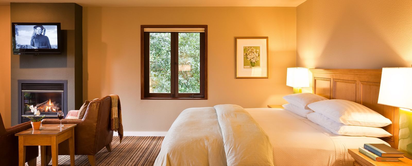 A spacious, sun-lit room with a king bed, a seating area, and warm decor - Brewery Gulch Inn & Spa