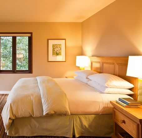 A spacious, sun-lit room with a king bed, a seating area, and warm decor - Brewery Gulch Inn & Spa