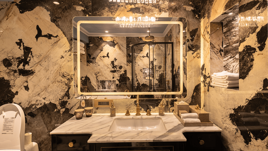 image of the bathroom with white and black gradient marble with a wide mirror above the wash basin at the heritage parlour suite - The Claridges New Delhi