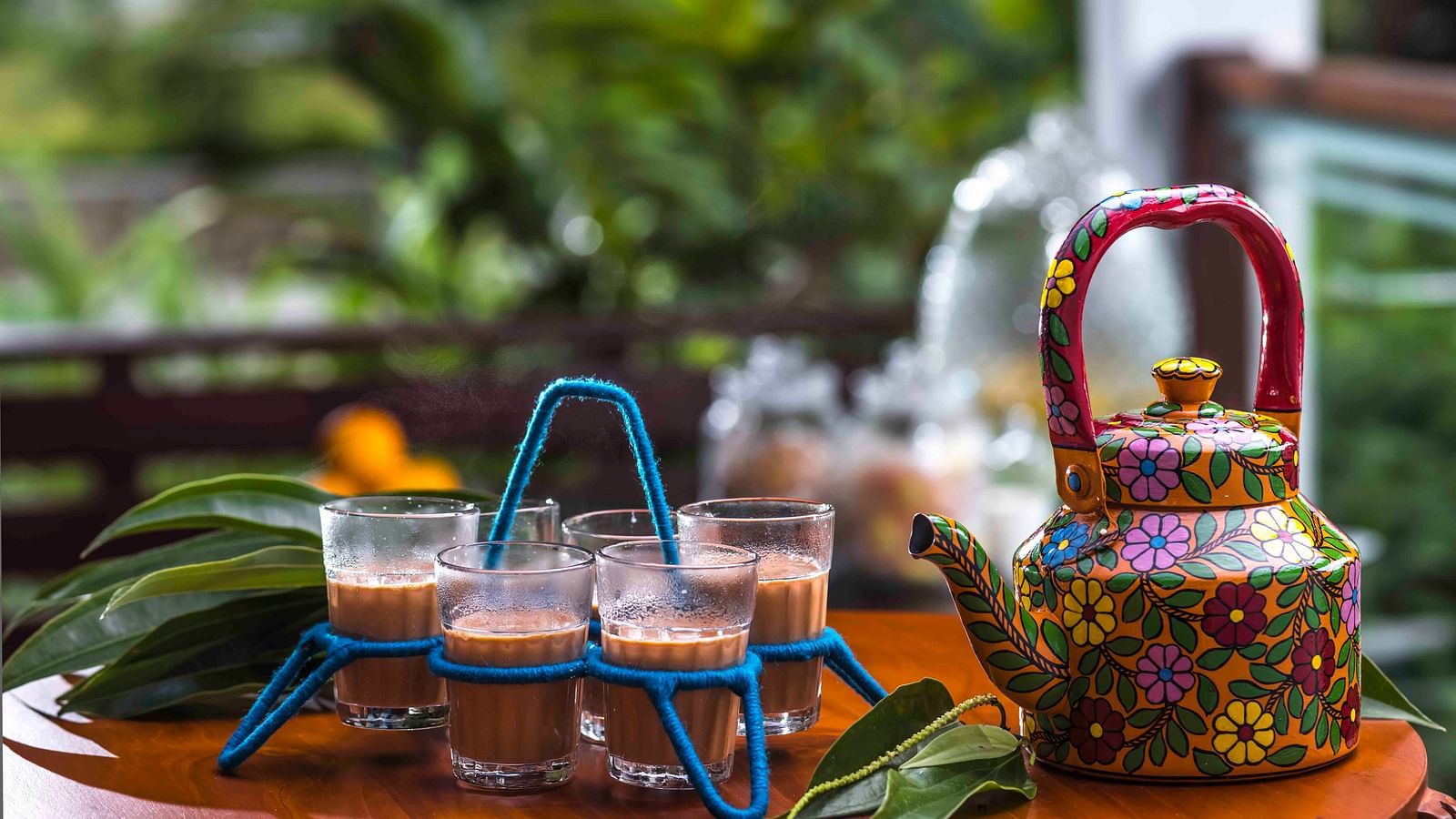 A shot of tea cups and a kettle kept at the table.