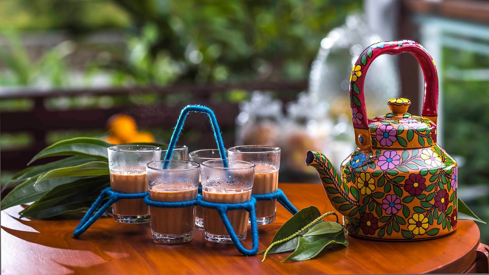 A shot of tea cups and a kettle kept at the table.