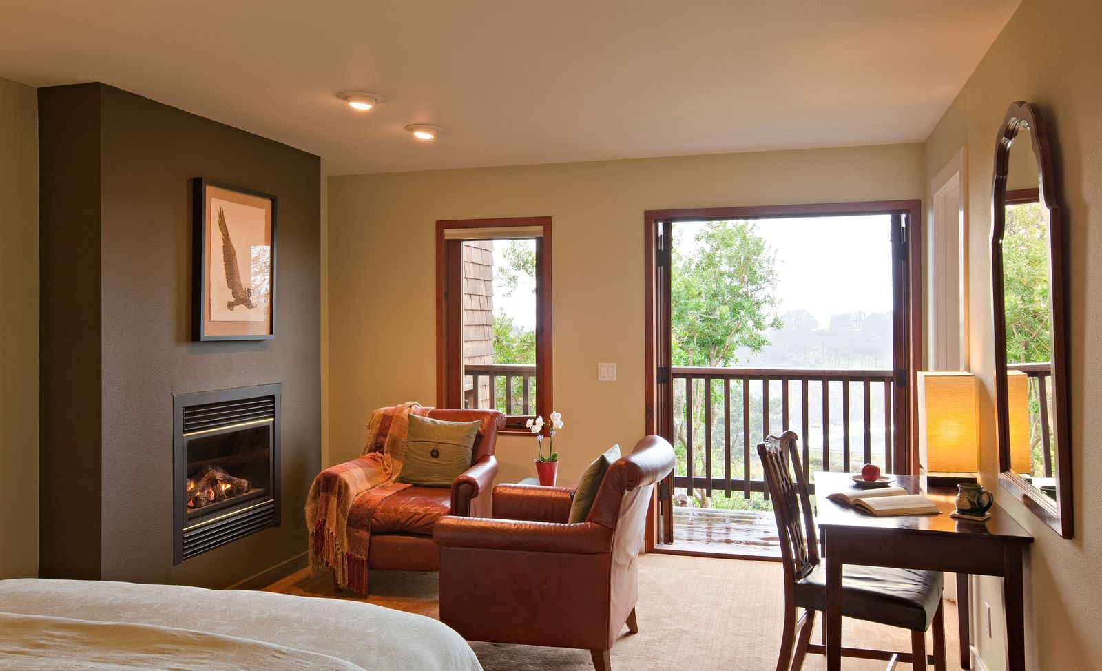 A well-furnished room with a comfortable chair and a view of nature, ideal for both relaxation and work - Brewery Gulch Inn & Spa