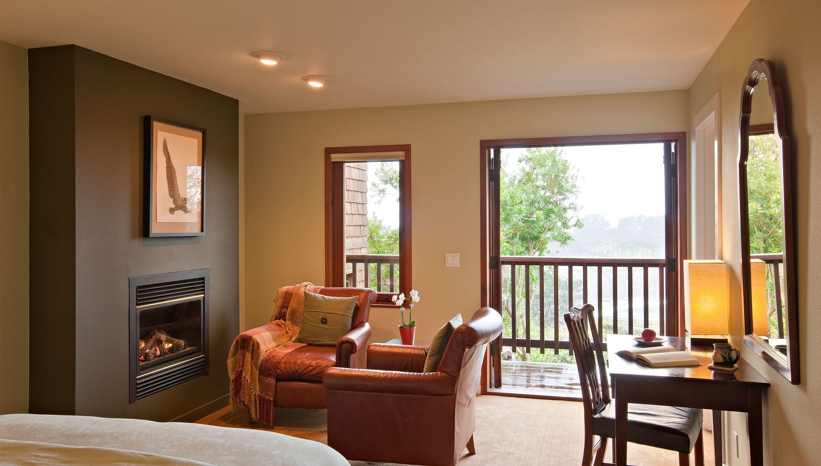 A well-furnished room with a comfortable chair and a view of nature, ideal for both relaxation and work - Brewery Gulch Inn & Spa