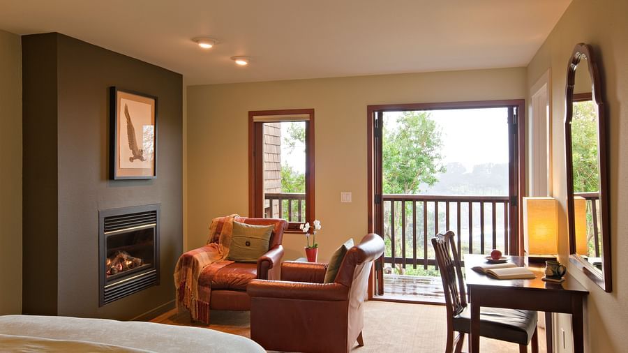 A well-furnished room with a comfortable chair and a view of nature, ideal for both relaxation and work - Brewery Gulch Inn & Spa