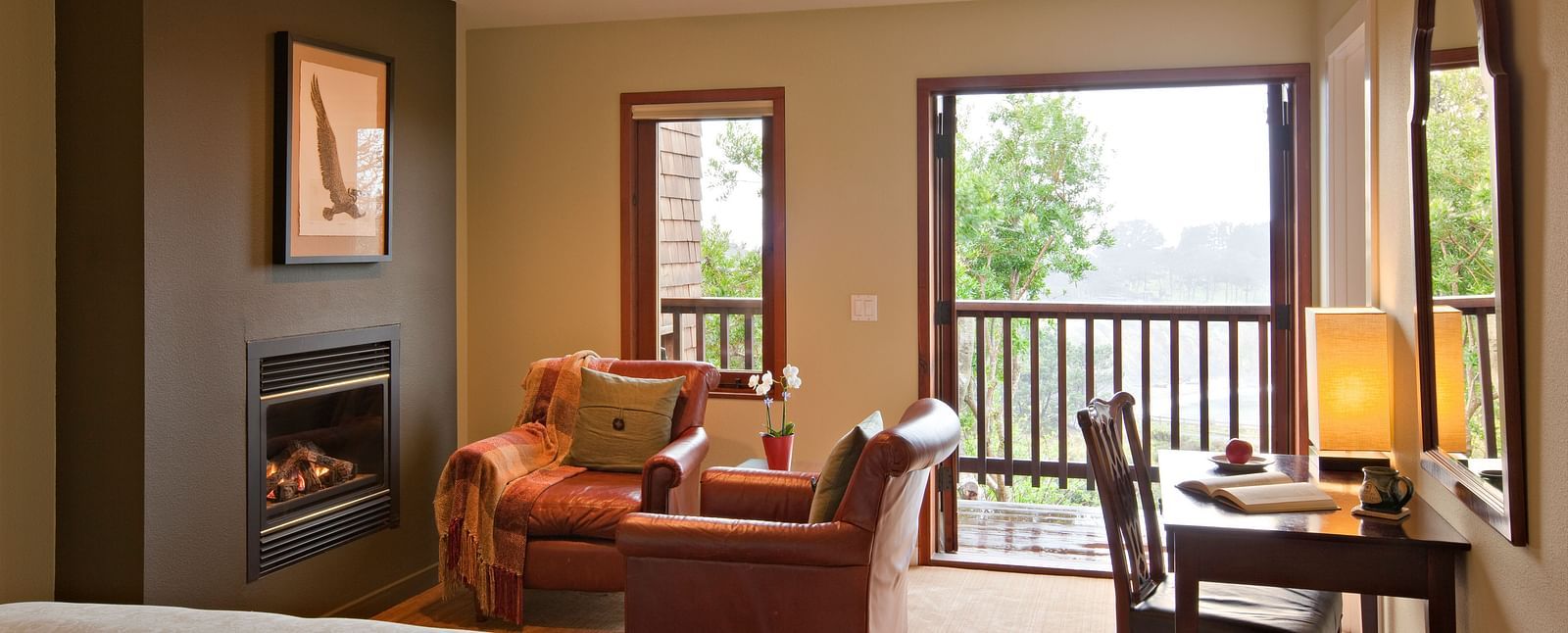 A well-furnished room with a comfortable chair and a view of nature, ideal for both relaxation and work - Brewery Gulch Inn & Spa