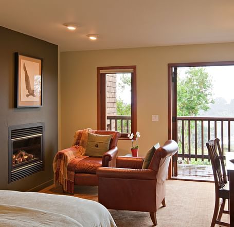 A well-furnished room with a comfortable chair and a view of nature, ideal for both relaxation and work - Brewery Gulch Inn & Spa