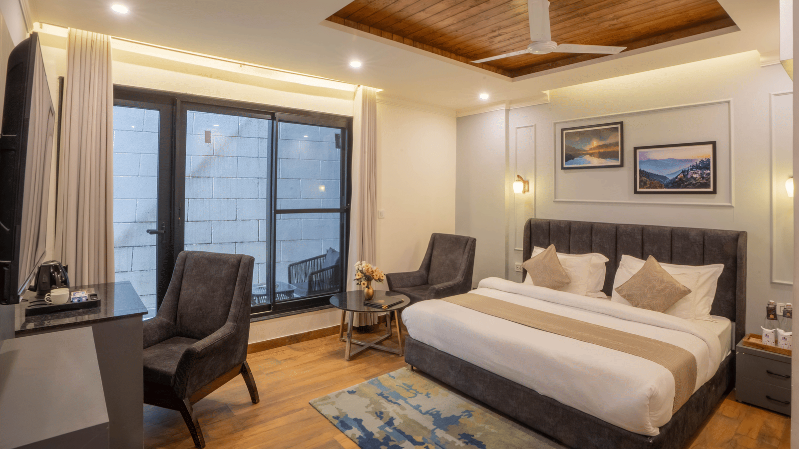 Full-view shot of the Super Deluxe Room With Shared Balcony featuring a double with a ceiling fan hanging above it at Perfectstayz Premium Westend Mall Road, Mussoorie.