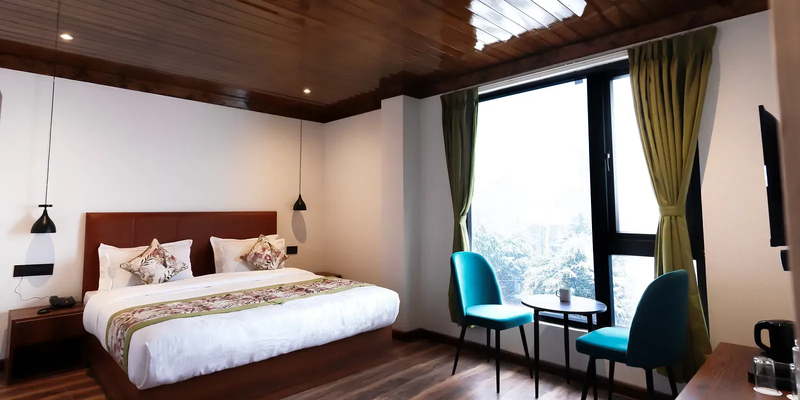 Modern bedroom with wooden ceiling, large bed, and mountain view at Avianna Mystique Valley, Lachung.