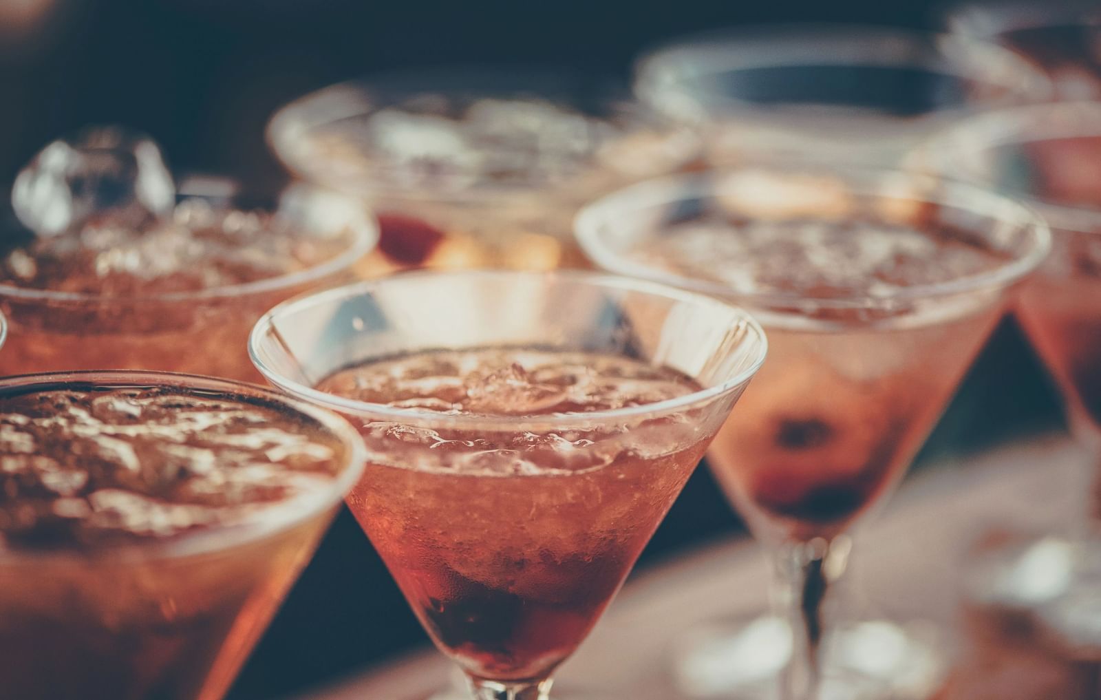 Several glasses filled with various colorful cocktails are arranged closely together, ready to be served | Altamont Court, Jamaica