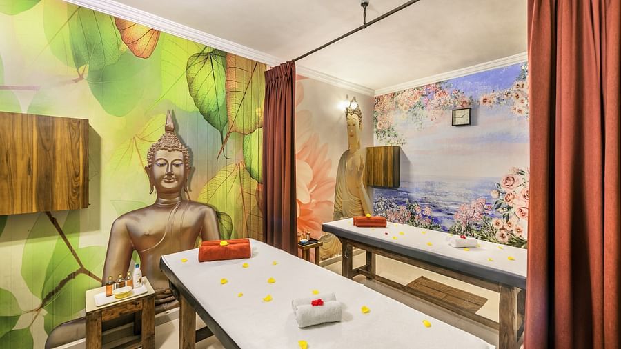 Spa therapy room at Golden Tulip, Candolim, Goa, with a serene mural of Buddha and neatly arranged massage beds.
