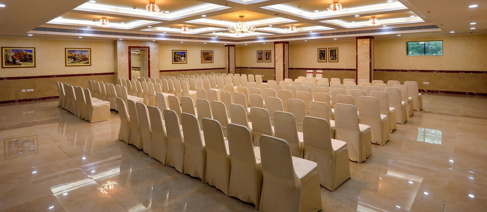 White chairs facing the stage in the Banquet Hall in Hotel Aadithya, Chennai 2