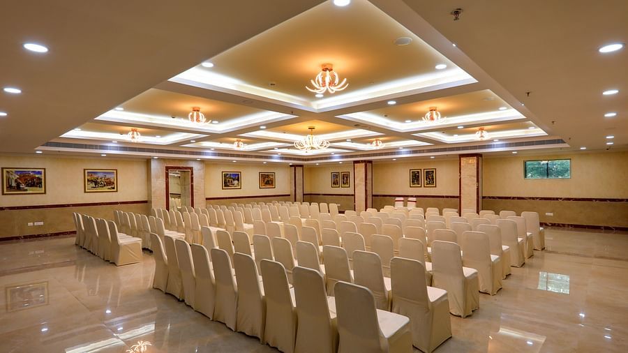White chairs facing the stage in the Banquet Hall in Hotel Aadithya, Chennai 2