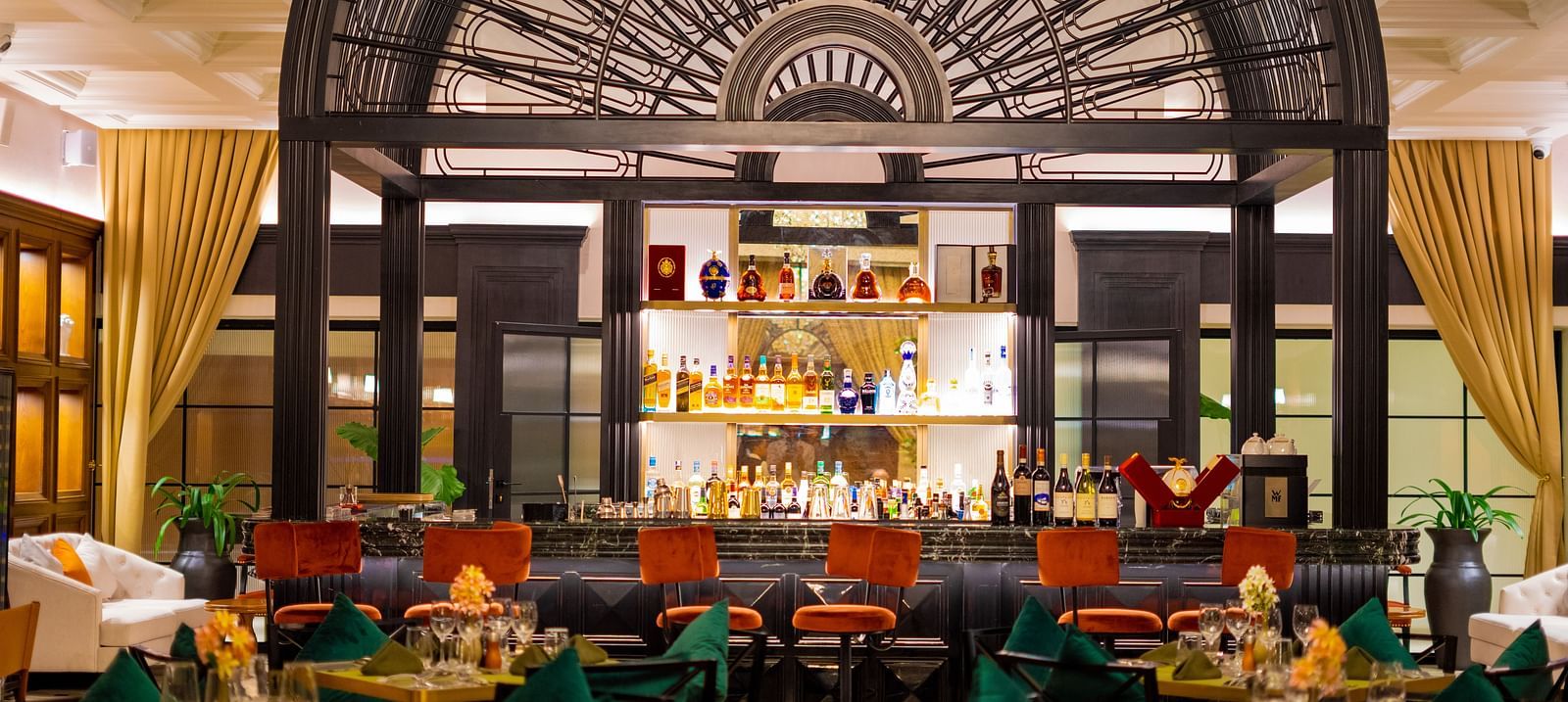 Aria Restaurant at KertelSuites, showcasing a stylish bar setup with neatly arranged tables and chairs