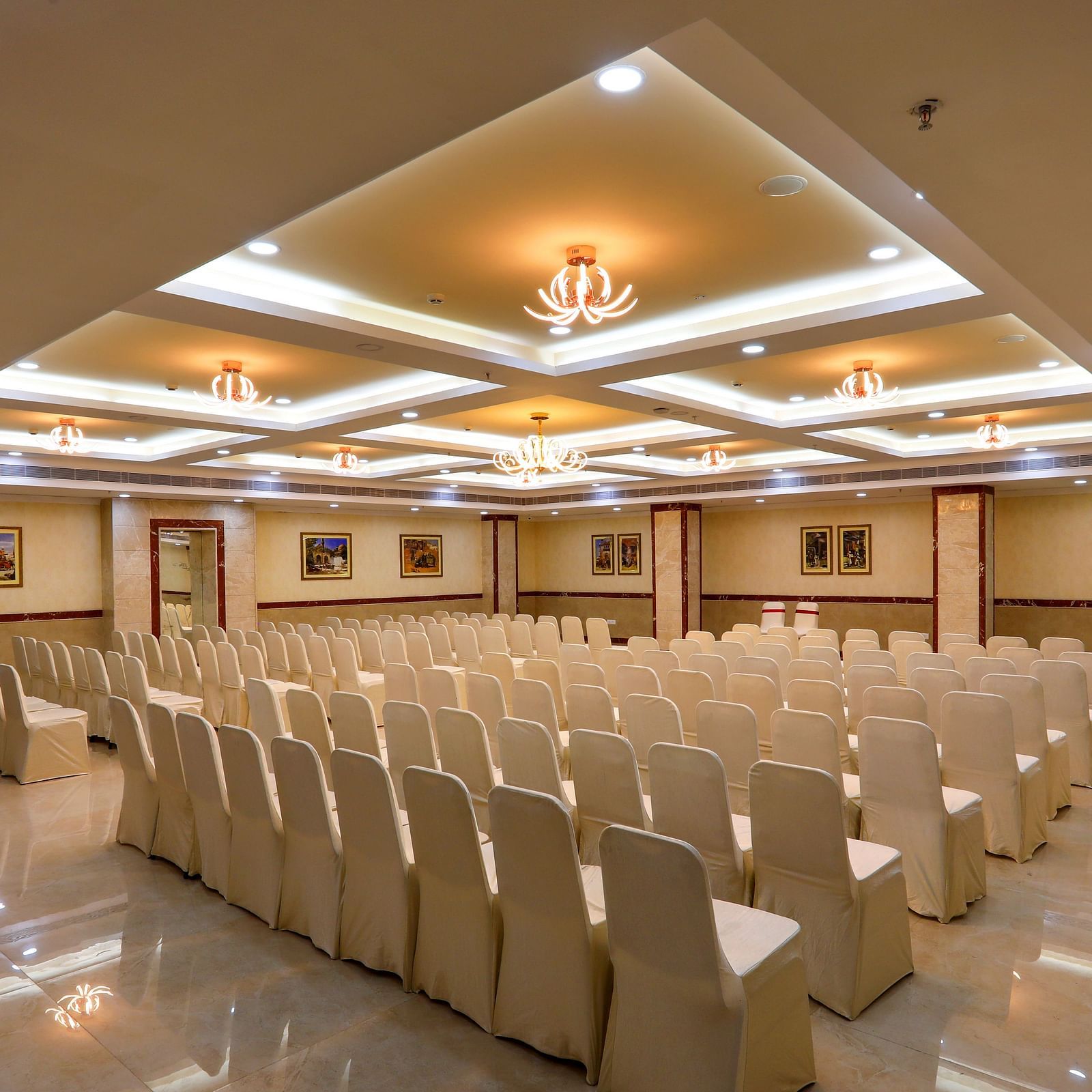 White chairs facing the stage in the Banquet Hall in Hotel Aadithya, Chennai 2