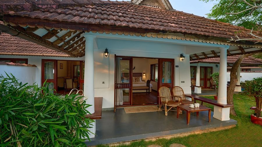 An image of a cottage with outdoor seating arrangements - Rhythm Kumarakom