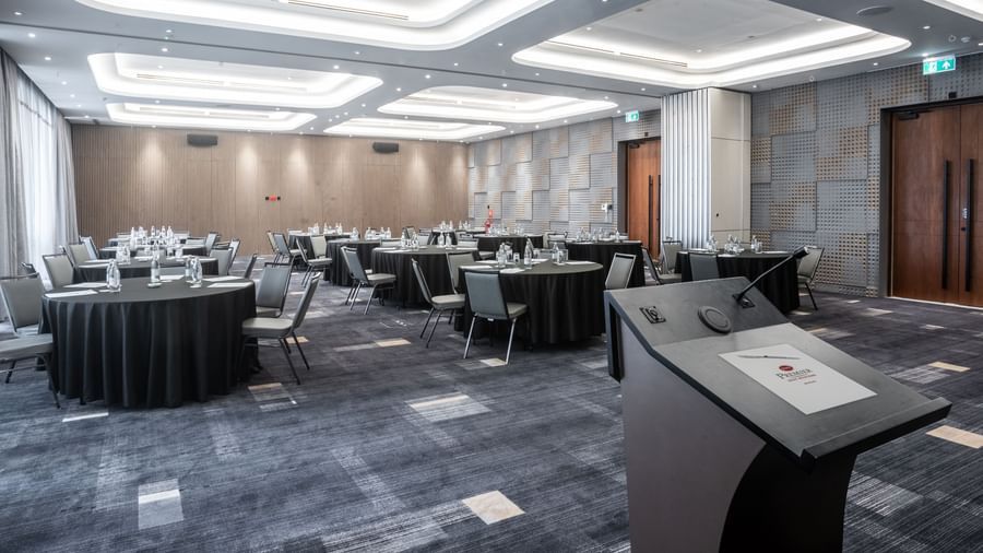 Modern event or meeting space at Best Western Premier Westlands hotel, arranged with circular tables and chairs beneath stylish recessed lighting.