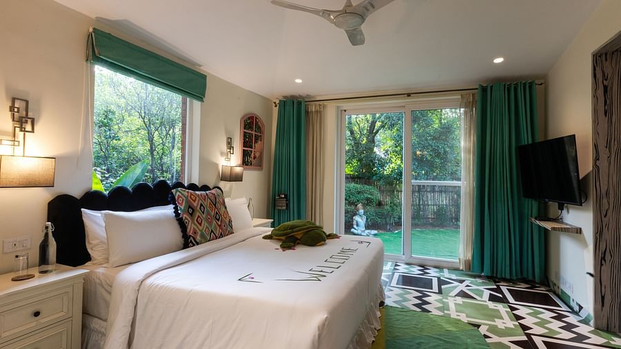 A double bed with a side table inside Garden Suite - Karma Lakelands.
